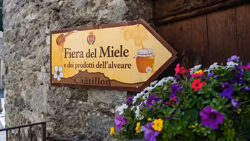 Guida con freccia di indicazione per la fiera del miele a Châtillon Valle d'Aosta